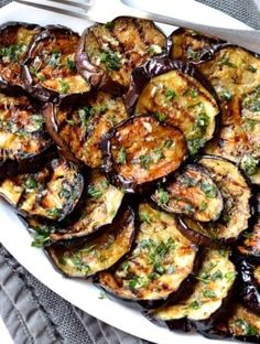 grilled eggplant and zucchini dish on a white platter with a fork