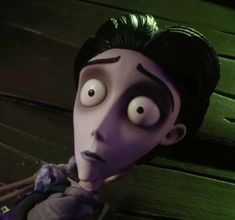 an animated character with green hair and black eyes holding two sticks in front of his face