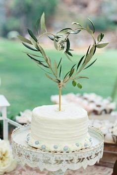 a white cake with an olive branch on top