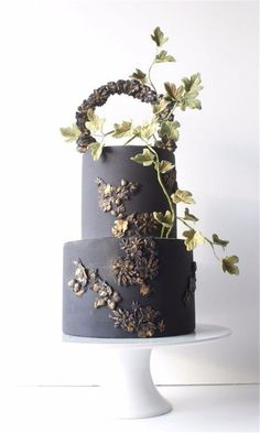 a three tiered cake decorated with flowers and leaves