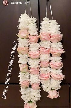 a bunch of white and pink flowers hanging from hooks