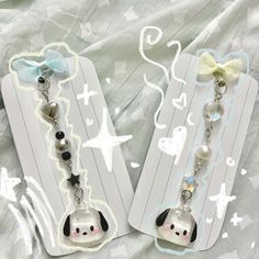 two key chains with dog charms attached to them