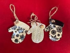 three christmas mittens hanging from twine on a red background