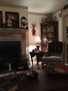 a living room filled with furniture and a fire place next to a mantle covered in pictures