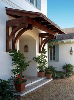 an outside view of a house with potted plants