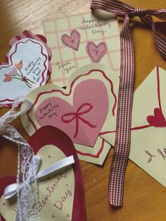 valentine's day cards are laid out on a table with ribbons and tags attached to them