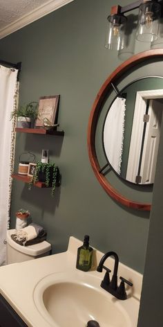 a bathroom with a sink, mirror and toilet paper roll on the shelf next to it