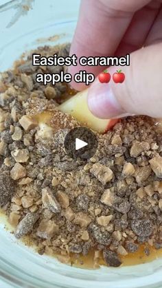 someone is adding caramel to an apple dip in a glass bowl with brown sugar