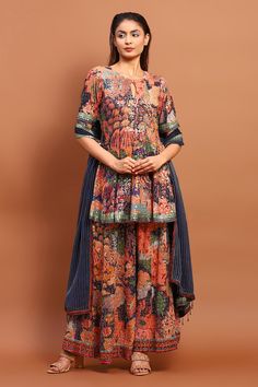 Navy blue peplum kurta with floral print and thread, sequin embroidery. Paired with flared pant and dupatta.
Components: 3
Pattern: Printed, Embroidery
Type Of Work: Floral, thread, sequin
Neckline: Round
Sleeve Type: Half
Fabric: Cotton Blend
Color: Blue
Other Details: 
Back deep V neck
Sequin lace embroidered border
Occasion: Sangeet - Aza Fashions Multicolor Anarkali Palazzo Set With Block Print, Multicolor Anarkali Palazzo Set With Kalamkari Print, Multicolor Kalamkari Sharara With Straight Kurta, Blue Kalamkari Print Sets For Festive Occasions, Multicolor Block Print Sharara For Diwali, Blue Saree Set With Kalamkari Print, Blue Kalamkari Wedding Set, Blue Bohemian Sharara With Straight Kurta, Blue Straight Kurta Set With Kalamkari Print