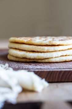 a stack of pancakes sitting on top of a wooden cutting board