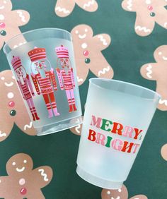 two shot glasses sitting on top of a table covered in hearts and snowflakes