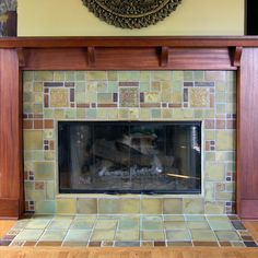 a fireplace with a clock above it in a room that has wood floors and yellow walls