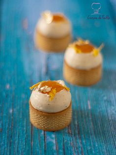 three small desserts are sitting on a blue table