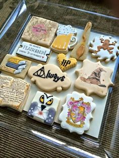 there are many decorated cookies on the glass platter, including harry potter and hogwarts