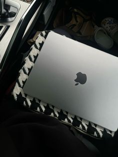 an apple laptop sitting on top of a bed