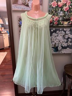 offered is a vintage 60s night gown by Pandora. I believe it to be unworn. It is in pristine condition. Lime green in color it is double nylon layers, the outer being floaty chiffon. The bodice is covered in tiny silver beads. The neckline has a attached scarf which goes through a loop at the back neckline and hangs gracefully. The gown is waltz length. Tagged as size large.  Bust measures 42 " Waist  48" Hips 50" Length from shoulder to hem is 39" Condition is excellent Green Summer Sleepwear For Wedding Night, Green Summer Wedding Night Sleepwear, Green Sleeveless Party Sleepwear, Green Sleeveless Summer Nightgown, Green Sheer Summer Sleepwear, Sheer Nightgown For Wedding Night In Spring, Spring Green Sleeveless Sleepwear, Green Sheer Sleepwear, Spring Chiffon Dresses For Wedding Night