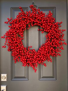 a red berry wreath hangs on the front door