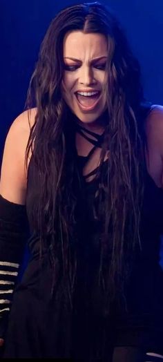 a woman with long hair and black dress on stage