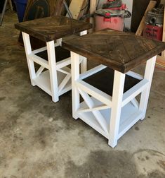 two wooden tables sitting next to each other on top of a cement floor in a garage