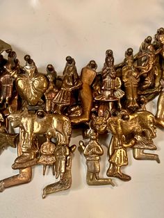 a group of gold colored figurines sitting on top of a white table next to each other