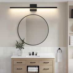 a bathroom with a round mirror above the sink