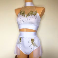 a mannequin wearing a white and gold outfit with sequins on it