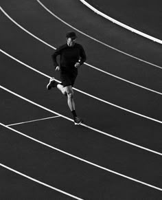 a man running on a track in black and white