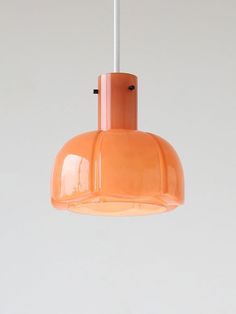 an orange glass light hanging from a ceiling