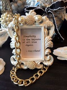 an ornate frame with a chain around it and a quote on the front saying simplicity is the key to all true signs coco chanel