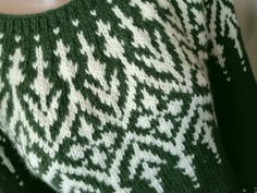 a green and white knitted sweater on a mannequin