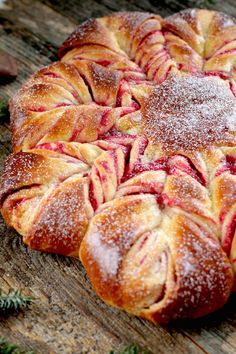 an apple croissant with powdered sugar on top sitting on a wooden table