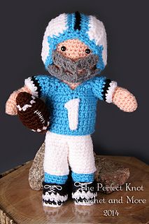 a crocheted blue and white football player doll with a ball in his hand