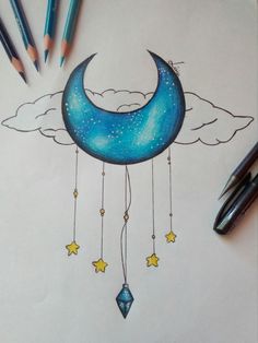 a drawing of a crescent moon with stars hanging from it's side and some pencils next to it