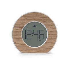 a wooden clock with the time displayed on it's face and an alarm display