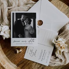 an envelope with a couple's wedding photo on it next to some white flowers