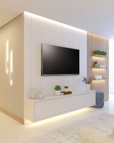 a living room with white furniture and a flat screen tv mounted on the wall above it