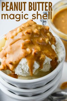 a bowl filled with ice cream covered in caramel sauce next to a jar of peanut butter