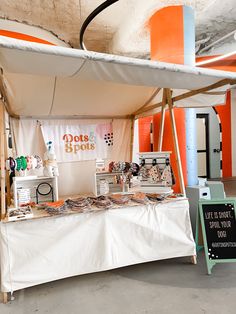 a tent with various items on it and a sign that says dots & spots next to it