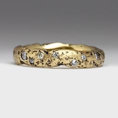 a gold wedding band with diamonds on it