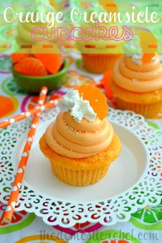 orange creamsice cupcakes on a white plate with an orange striped straw