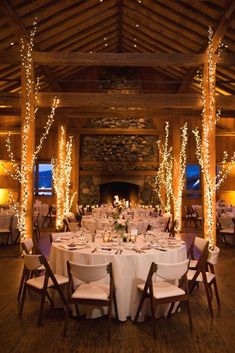 the tables are set with white linens and lighted trees