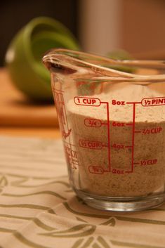 a measuring cup filled with food on top of a table