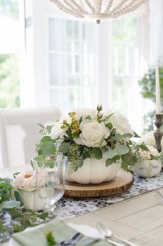 the table is decorated with white flowers and greenery