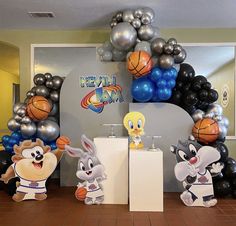 an indoor basketball themed birthday party with balloon decorations and balloons in the shape of animals