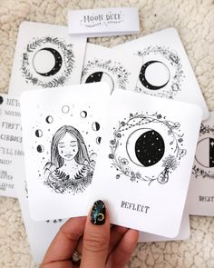 a person holding up four cards in their hand with the moon and crescent designs on them