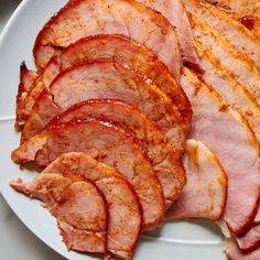 slices of ham on a white plate ready to be cooked