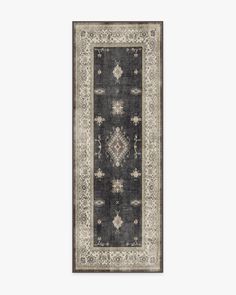 a rug with an ornate design on the bottom, and a border in grey tones