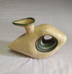 a ceramic vase sitting on top of a white sheet