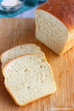 two loaves of bread sitting on top of a wooden cutting board