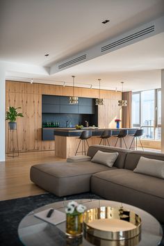 a living room filled with furniture next to a kitchen